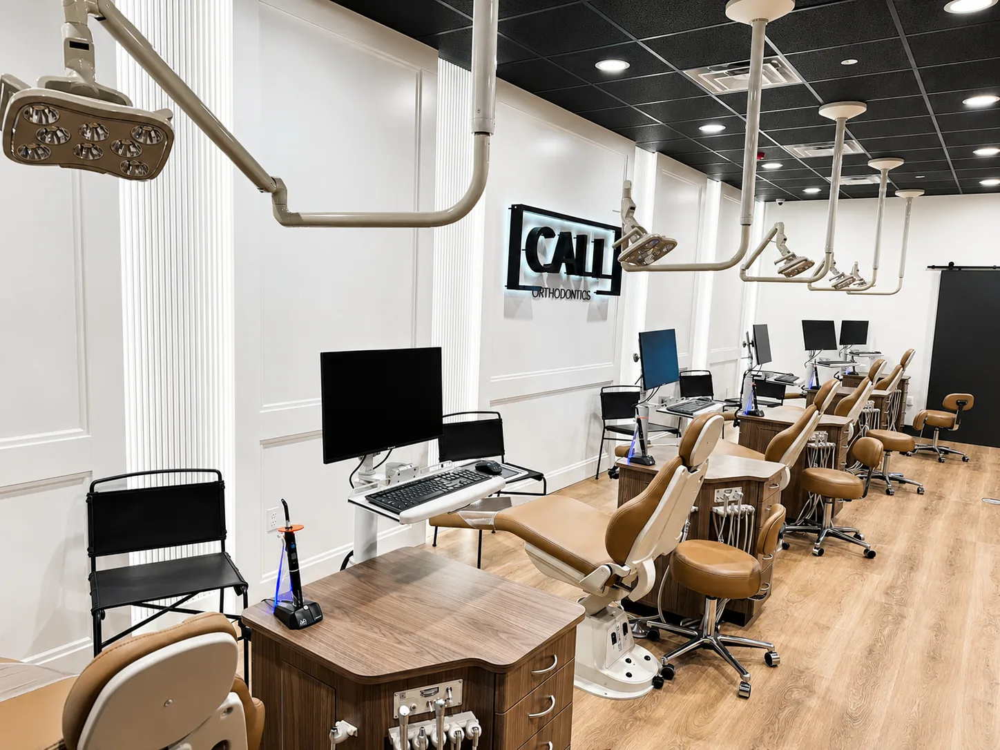 Long view of the Call Orthodontics operatory showing multiple technology-equipped treatment stations